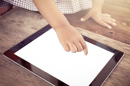 Child hand pointing smart phone,tablet for playing and education in vintage color toneの写真素材