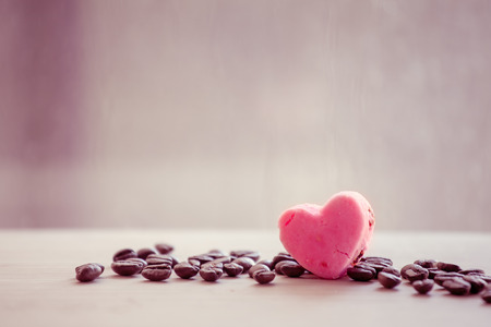heart pink cookies with coffee bean on rainy day window background in vintage color toneの写真素材