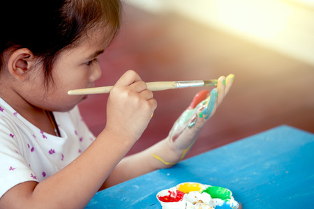 little girl is painting her handの写真素材
