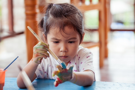 little girl is painting her handの写真素材