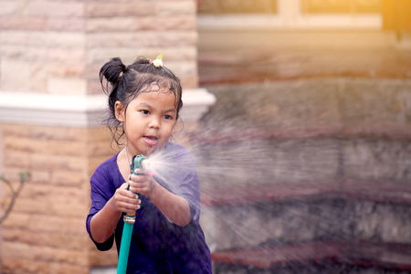 Happy asian little girl having fun to play water in Songkran festival Thailandの写真素材
