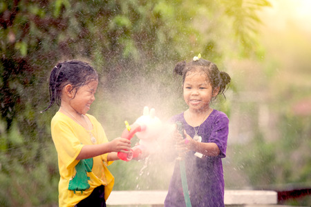 Two asian little girls having fun to play water together in Songkran festival Thailandの写真素材