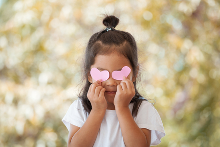 Cute asian little girl with hearts on the eyesの写真素材