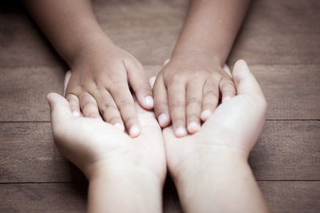 Mother and child daughter holding hand together with love in vintage color toneの写真素材