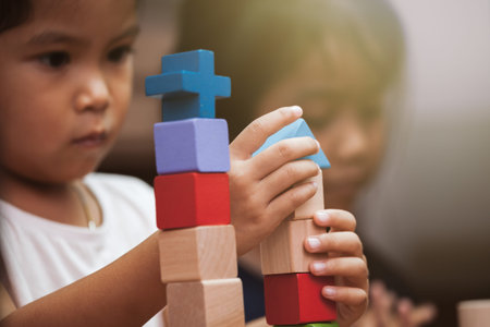 Focus on child's hand  playing with colorful wooden blocks in vintage color tone