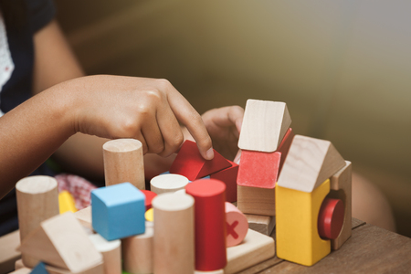 Focus on child's hand  playing with colorful wooden blocks in vintage color toneの写真素材
