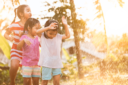 Asian children having fun to play with the rain together in the park in vintage color toneの写真素材