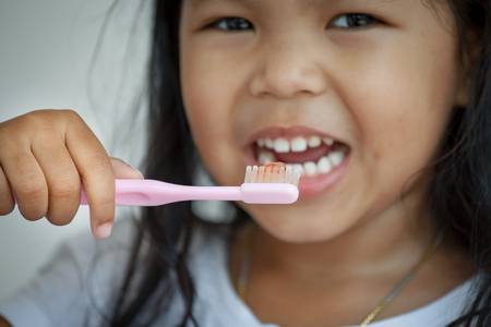 Asian little girl brushing her teeth close up on toothbrushの写真素材