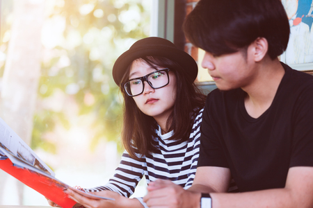 Young love couple reading a book together in the cafe in vintage color toneの写真素材