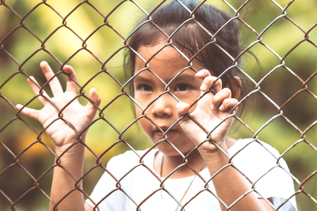 Child little girl hand holding steel mesh in vintage color toneの写真素材