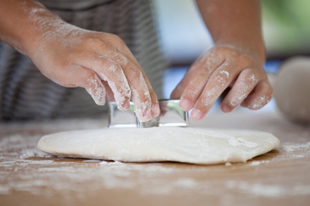 Little child girl hands kneading dough prepare for baking cookiesの写真素材