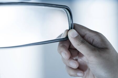 Woman hands  adjusting rear view mirror in the car in vintage color toneの写真素材