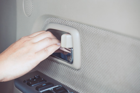 Woman hand pulling  handle to open car door from inside the carの写真素材