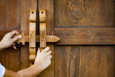 Woman hand opening/closing wooden door in vintage styleの写真素材