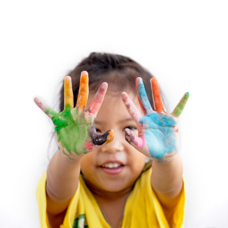 Cute asian child girl with hands painted in colorful paint on white backgroundの写真素材