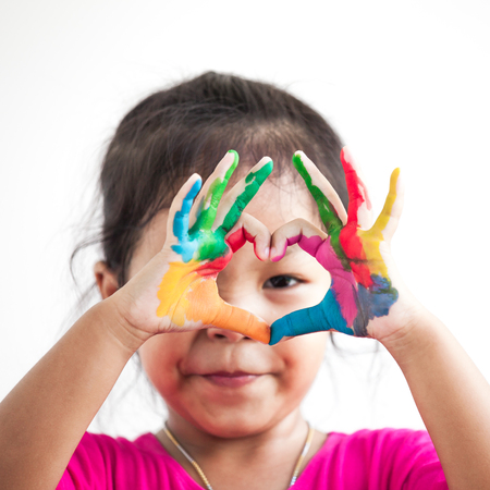 Cute asian child girl with hands painted make heart shape on white backgroundの写真素材