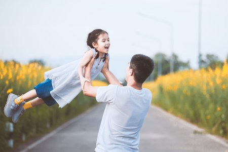 Happy asian father holding his kid spinning around with fun in the park in vintage color toneの写真素材