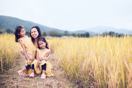 Happy asian little child girls having fun to play with mother in the paddy field in vintage color toneの写真素材