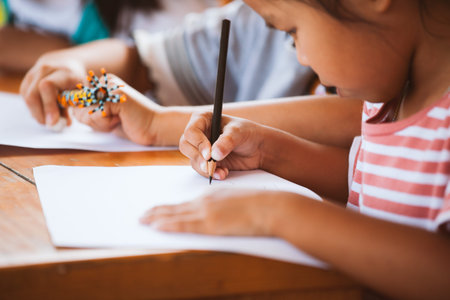 Asian child girl drawing and painting with her friend with fun together