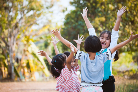 Asian children raise hands and playing together with fun in the parkの写真素材