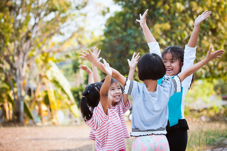 Asian children raise hands and playing together with fun in the parkの写真素材