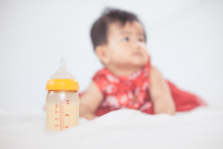 Baby bottle with breast milk for breastfeeding on little baby girl background. Mothers breast milk is the most healthy food for newborn baby.の写真素材