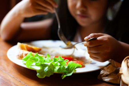 Asian child girl eating delicious Spaghetti Carbonara in the restaurantの写真素材