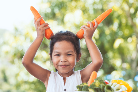 Cute asian child girl having fun to learn about vegetables with happinessの写真素材