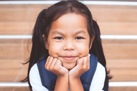Back to school. Portrait of cute asian child girl with school bag smiling at schoolの写真素材
