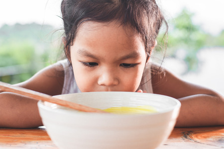 Cute asian child girl bored to eat Instant noodles for her mealの写真素材