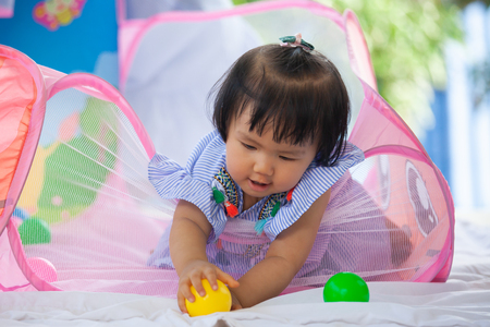 Cute asian baby girl playing with her toy with happinessの写真素材