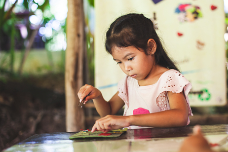 Cute asian child girl make a craft with recycling paper from poop of elephants in learning centerの写真素材