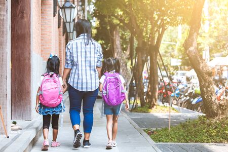 Back to school. Asian mother and daughter pupil girl with backpack holding hand and going to school togetherの写真素材
