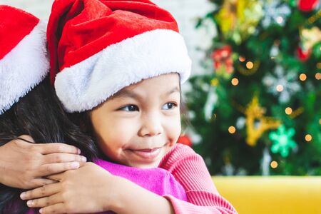 Cute asian child girl hugging her mother with love in Christmas celebrationの写真素材