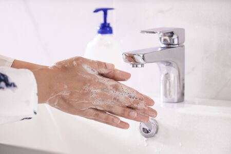 Women washing hands with antibacterial soap sanitizer or alcohol gel for corona covid-19 virus prevention. Hygiene to stop spreading of germs and bacteria and avoid infections corona covid-19 virus.の写真素材