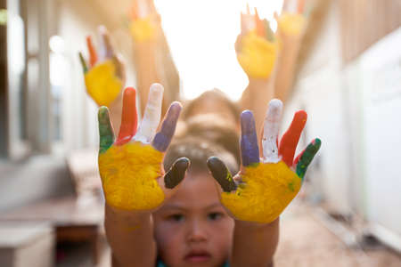 Cute asian child boy and girl with painted hands playing together with fun and happinessの写真素材
