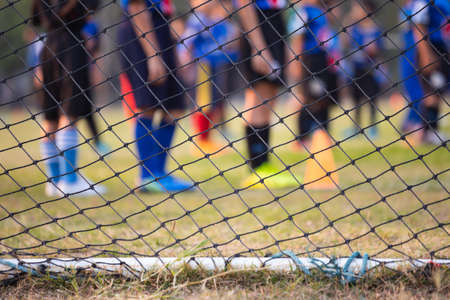 Soccer or football net background, view from behind the goal with blurred of football playerの写真素材