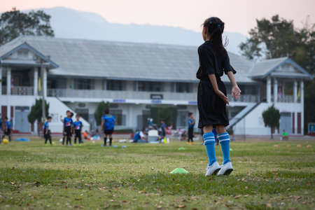 Asian child girl exercise warm up before play soccer with coach and friend. Kid sport recreation concept.の写真素材