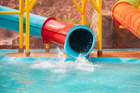 Asian child girl having fun to slide down on water slide in a water park at the summer time.の写真素材