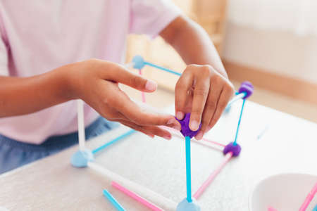 Cute asian child girl playing and creating with playdough and straws.の写真素材