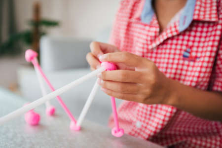 Cute asian child girl playing and creating with playdough and straws.の写真素材