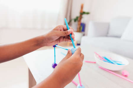 Cute asian child girl playing and creating with playdough and straws.の写真素材