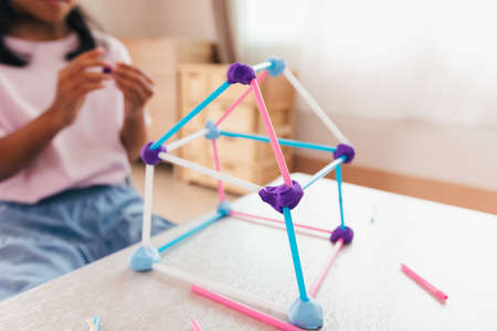Cute asian child girl playing and creating with playdough and straws.の写真素材