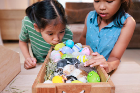 Asian siblings children are playing with baby bunny and decorating easter eggs preparing for Easter at home together with fun. Happy family Happy easter Happy holiday.の写真素材