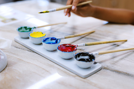 Close-up on oil colorful palette with paint brush. Kids art and craft creative activity class in workshop. DIY for kids, home activities, handmade decorations.の写真素材