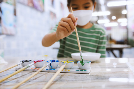 Close-up on oil colorful palette with paint brush. Kids art and craft creative activity class in workshop. DIY for kids, home activities, handmade decorations.の写真素材