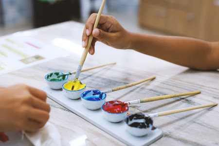 Close-up on oil colorful palette with paint brush. Kids art and craft creative activity class in workshop. DIY for kids, home activities, handmade decorations.の写真素材