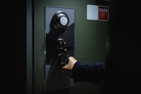 Hand holding locked handle to open the safe box. Keep money and valuables in the vintage safe box...