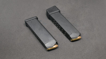 Two 9mm loaded magazines on black background