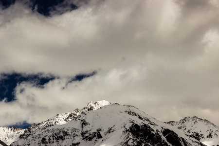 mountain peak under the cover of clouds and snow